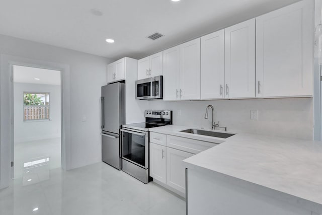 5305 Cleveland Rd, Delray Beach, FL 33484 - kitchen featuring stainless steel appliances, a sink, light countertops, white cabinets, and recessed lighting