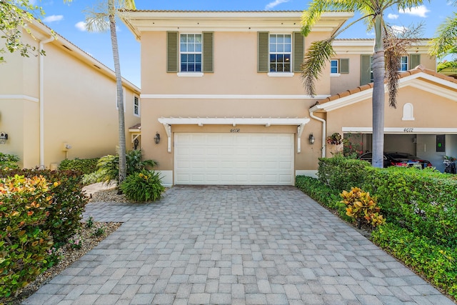 4608 Cadiz Cir, Palm Beach Gardens, FL 33418 - view of front of property with stucco siding, decorative driveway, an attached garage, and a tile roof