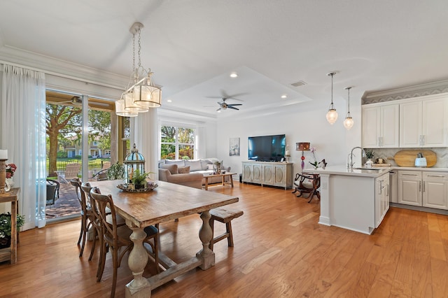 4608 Cadiz Cir, Palm Beach Gardens, FL 33418 - dining area with a ceiling fan, light wood-style flooring, recessed lighting, a tray ceiling, and crown molding