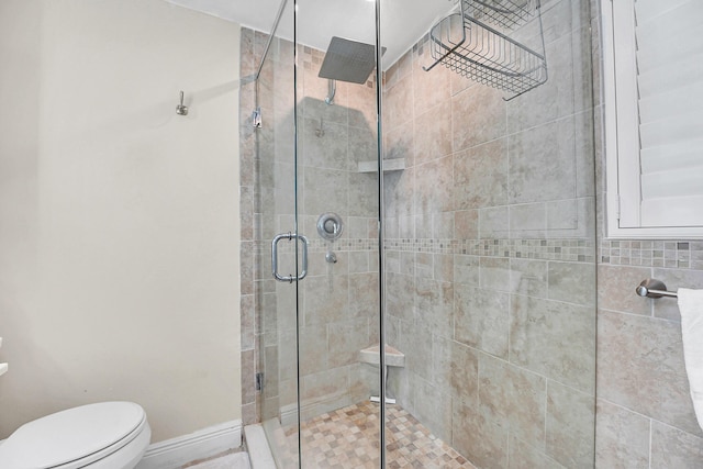 bathroom featuring a stall shower and toilet