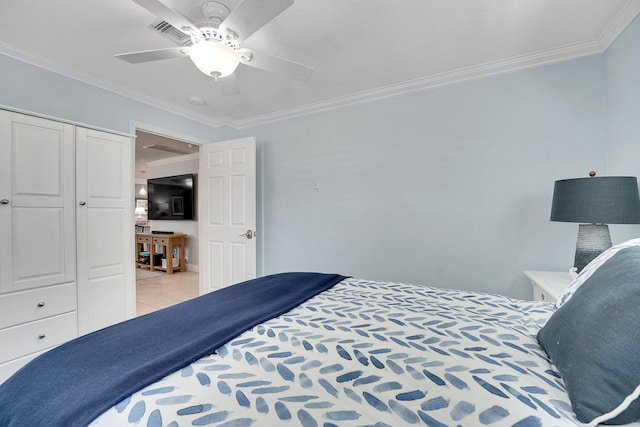bedroom with crown molding, ceiling fan, light tile patterned floors, and a closet