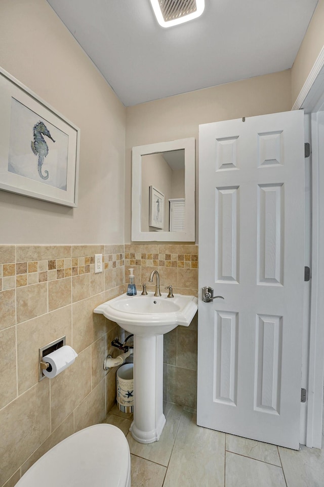 bathroom featuring tile walls, toilet, and tile patterned flooring