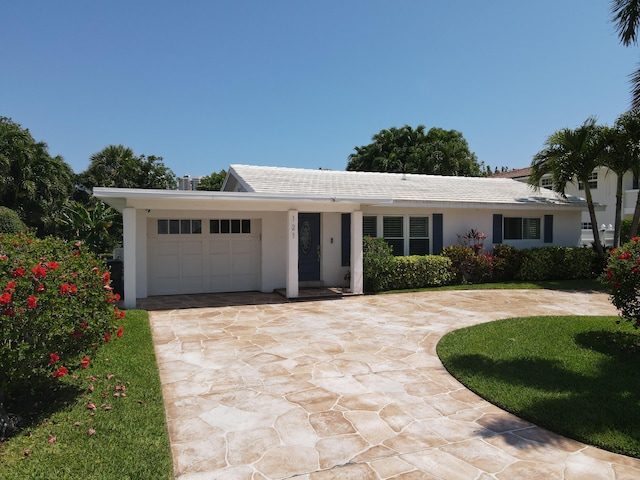 ranch-style house with an attached garage, stucco siding, and concrete driveway