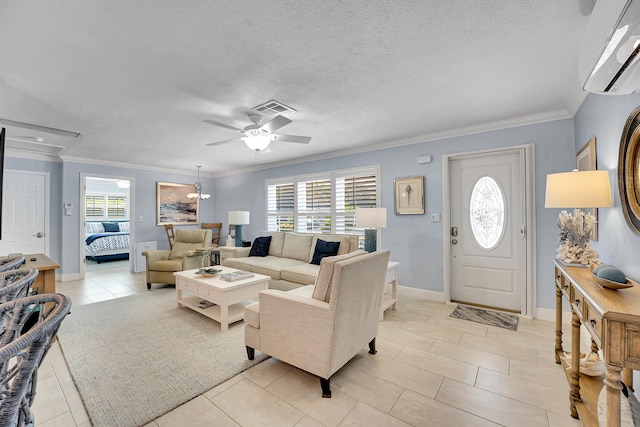 living area with plenty of natural light, ceiling fan, light tile patterned floors, ornamental molding, and a textured ceiling