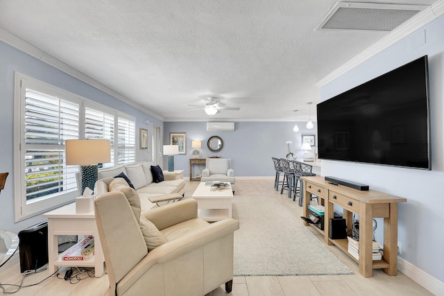 living area featuring a wall mounted air conditioner, ornamental molding, ceiling fan, a textured ceiling, and baseboards