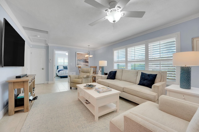 living room with ornamental molding, a ceiling fan, light tile patterned floors, baseboards, and a textured ceiling