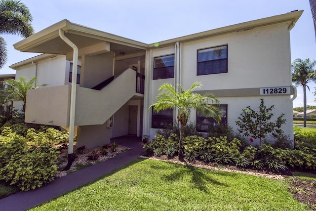 view of front of property with a front yard and stucco siding