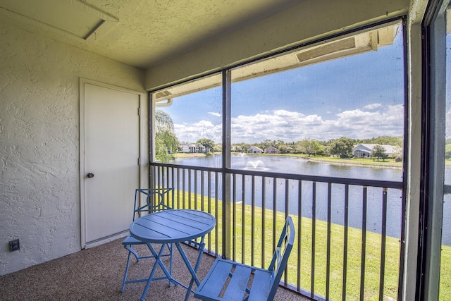 sunroom / solarium featuring a water view