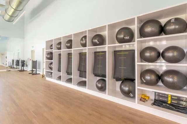 exercise room featuring wood finished floors and baseboards