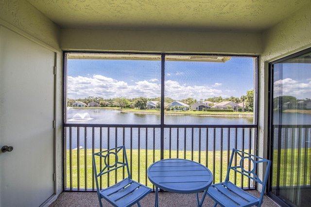 sunroom / solarium featuring a water view