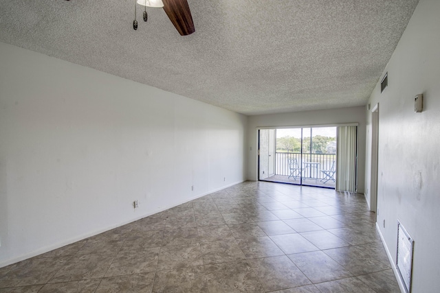 empty room featuring a textured ceiling, ceiling fan, and baseboards