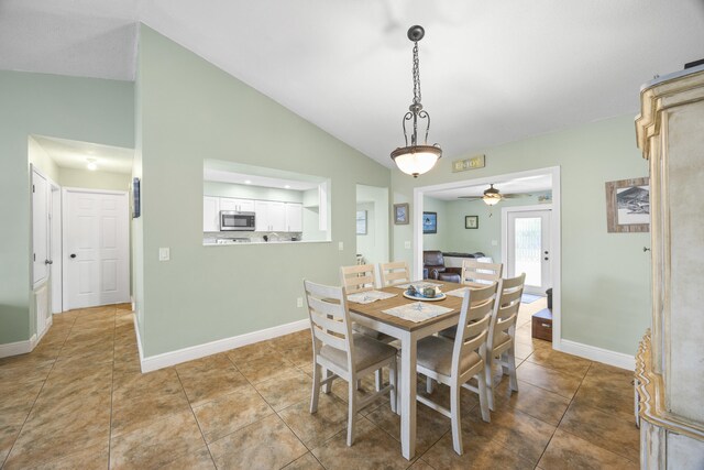 2442 SW Lafayette St, Port Saint Lucie, FL 34984 - tiled dining room with vaulted ceiling, a ceiling fan, and baseboards