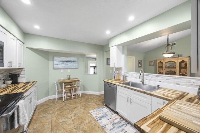 2442 SW Lafayette St, Port Saint Lucie, FL 34984 - kitchen featuring appliances with stainless steel finishes, a sink, wood counters, backsplash, and recessed lighting