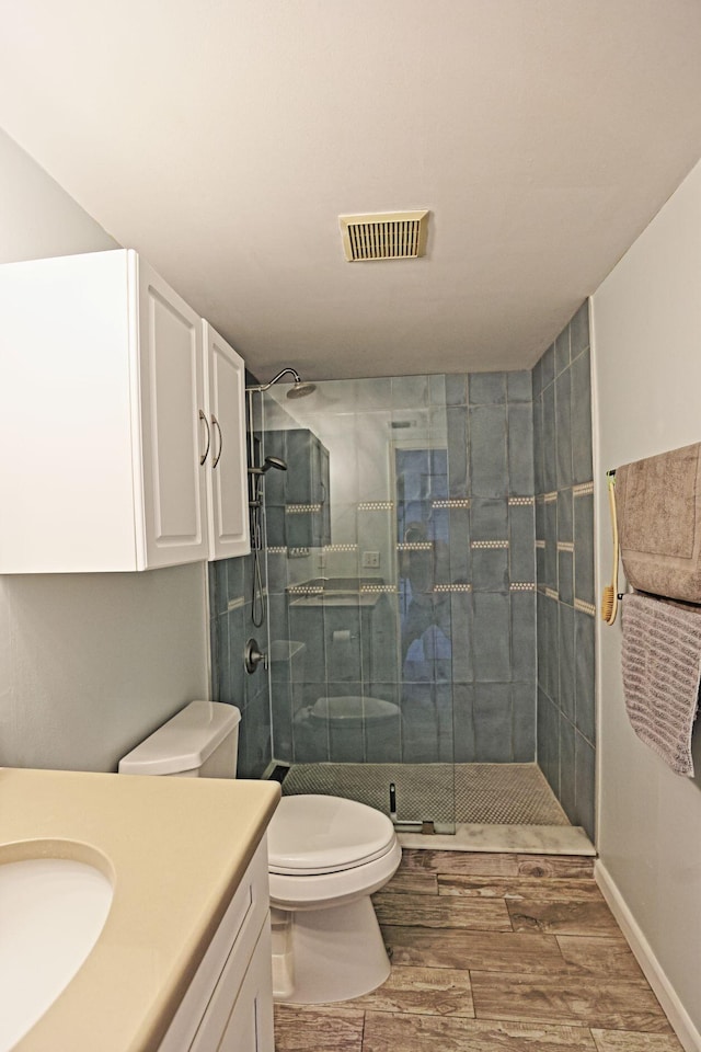 2950 SE Ocean Blvd Unit 127-8, Stuart, FL 34996 - full bathroom featuring toilet, vanity, a stall shower, and wood finished floors