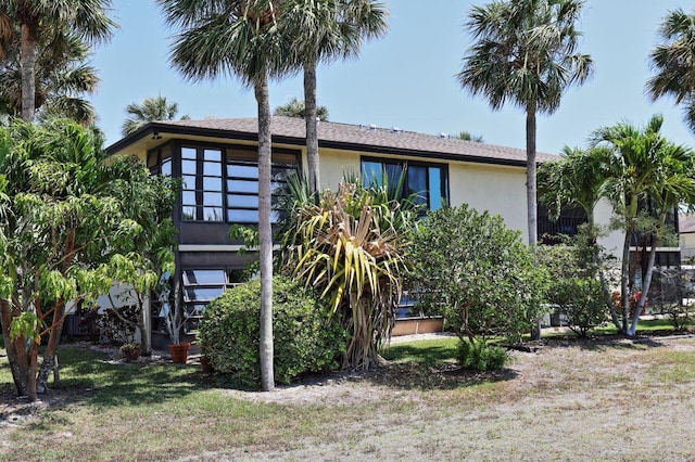 2950 SE Ocean Blvd Unit 127-8, Stuart, FL 34996 - back of property with stucco siding, stairs, and a yard