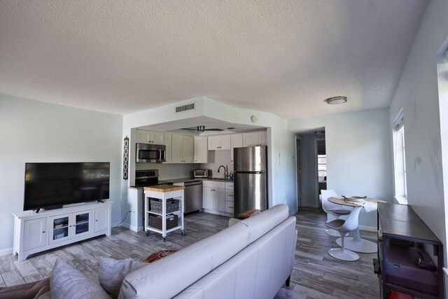 2950 SE Ocean Blvd Unit 127-8, Stuart, FL 34996 - living room with a textured ceiling, dark wood finished floors, and baseboards