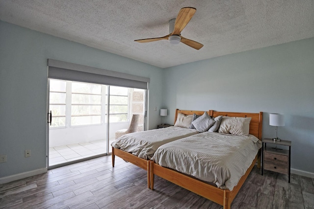 2950 SE Ocean Blvd Unit 127-8, Stuart, FL 34996 - bedroom with wood finished floors, a textured ceiling, ceiling fan, access to exterior, and baseboards