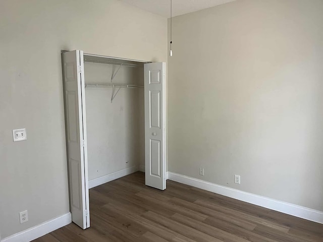 12299 Wedge Way, Boynton Beach, FL 33437 - unfurnished bedroom featuring dark wood finished floors, baseboards, and a closet