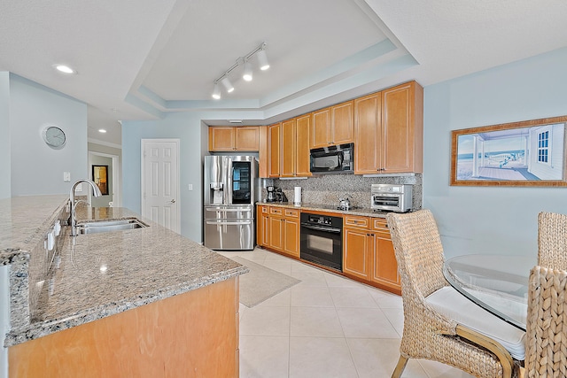 230 Ocean Grande Blvd Unit 501, Jupiter, FL 33477 - kitchen featuring black appliances, a sink, backsplash, a tray ceiling, and light tile patterned floors