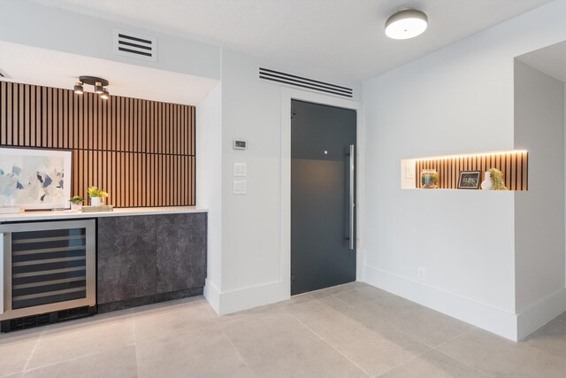 2800 E Sunrise Blvd Unit 4C, Fort Lauderdale, FL 33304 - indoor dry bar with wine cooler, light tile patterned flooring, and baseboards