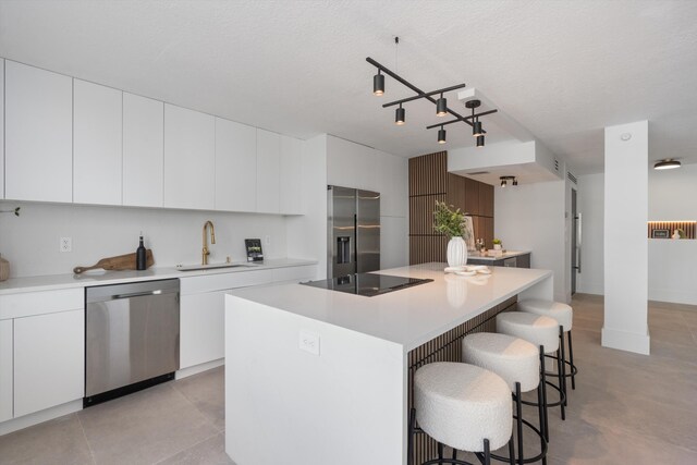 2800 E Sunrise Blvd Unit 4C, Fort Lauderdale, FL 33304 - kitchen featuring appliances with stainless steel finishes, a sink, a kitchen breakfast bar, and modern cabinets