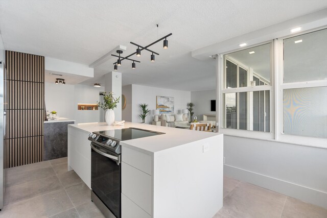 2800 E Sunrise Blvd Unit 4C, Fort Lauderdale, FL 33304 - kitchen with stainless steel electric range, modern cabinets, a center island, white cabinets, and light countertops