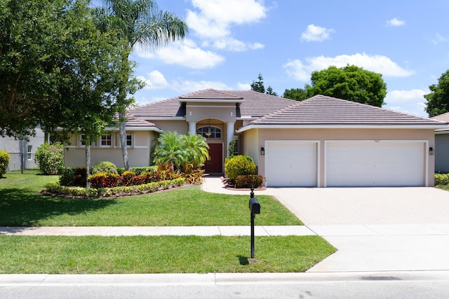 9413 Bristol Ridge Ct, West Palm Beach, FL 33411 - view of front of house featuring driveway, a garage, a front yard, a tiled roof, and stucco siding