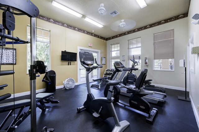 9413 Bristol Ridge Ct, West Palm Beach, FL 33411 - workout area featuring plenty of natural light, a textured ceiling, and baseboards