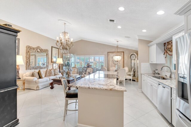 7780 Lake Champlain Ct, Delray Beach, FL 33446 - kitchen with appliances with stainless steel finishes, a sink, lofted ceiling, a kitchen island, and light stone counters