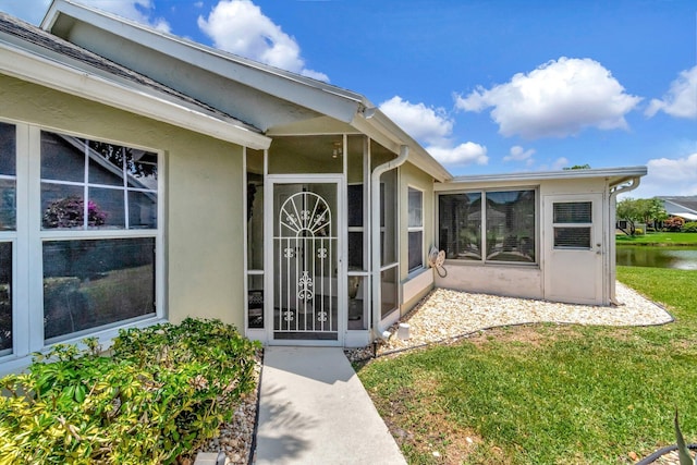 7780 Lake Champlain Ct, Delray Beach, FL 33446 - doorway to property featuring stucco siding, a water view, and a yard