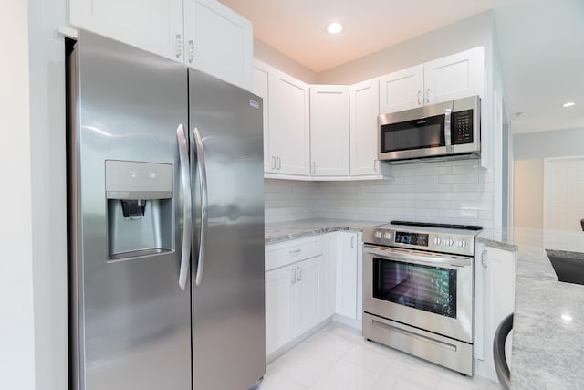3185 Laurel Ridge Cir, Riviera Beach, FL 33404 - kitchen with appliances with stainless steel finishes, light stone counters, tasteful backsplash, white cabinets, and recessed lighting
