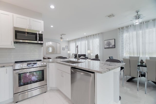 3185 Laurel Ridge Cir, Riviera Beach, FL 33404 - kitchen featuring stainless steel appliances, ceiling fan, light marble finish floors, a sink, and recessed lighting