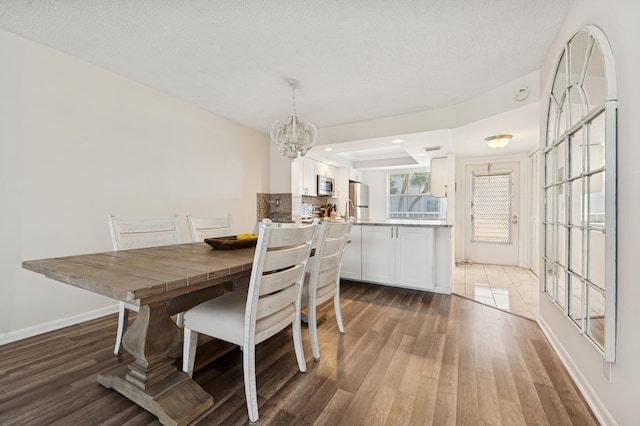 911 Gardenia Dr Unit 252, Delray Beach, FL 33483 - dining room with wood finished floors, a chandelier, baseboards, and a tray ceiling