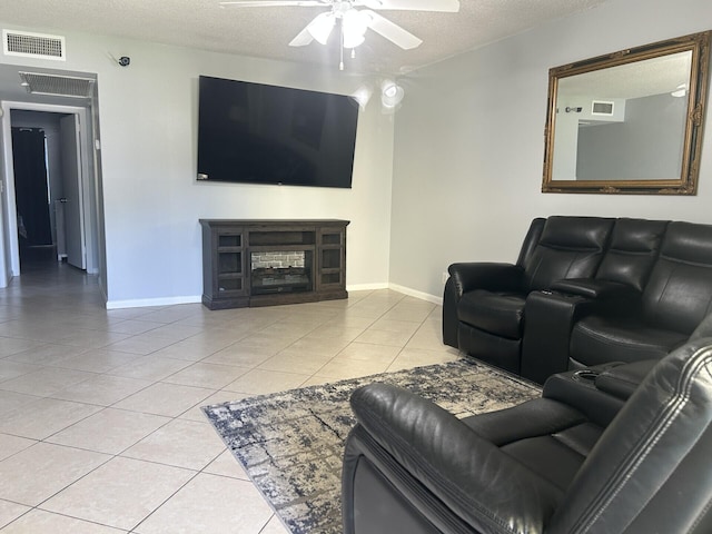 105 Sheffield E, West Palm Beach, FL 33417 - living room with a textured ceiling, ceiling fan, light tile patterned flooring, baseboards, and a glass covered fireplace