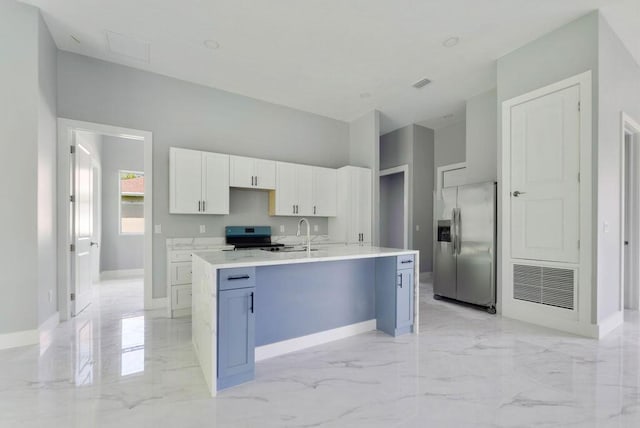 675 NE Moss Rose Pl, Port Saint Lucie, FL 34983 - kitchen featuring stainless steel appliances, light marble finish floors, baseboards, white cabinets, and light countertops