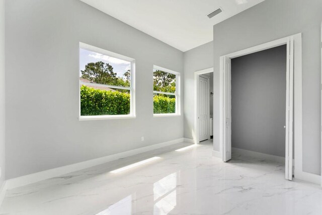675 NE Moss Rose Pl, Port Saint Lucie, FL 34983 - unfurnished bedroom with light marble finish floors and baseboards