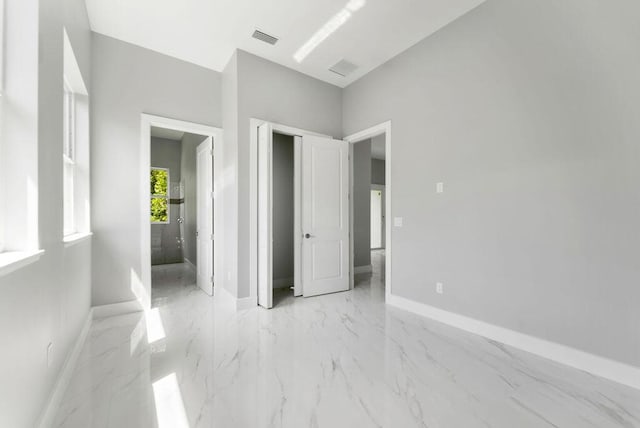 675 NE Moss Rose Pl, Port Saint Lucie, FL 34983 - unfurnished bedroom featuring baseboards, light marble finish flooring, and a closet