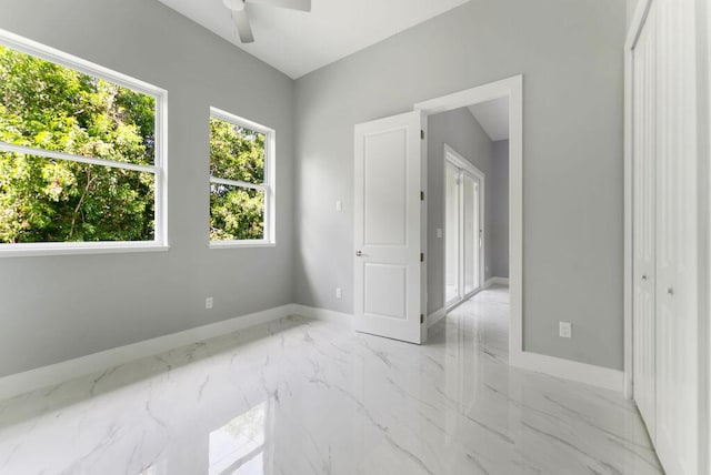 675 NE Moss Rose Pl, Port Saint Lucie, FL 34983 - unfurnished room featuring baseboards, ceiling fan, and light marble finish floors