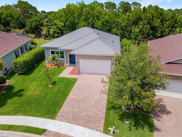675 NE Moss Rose Pl, Port Saint Lucie, FL 34983 - single story home featuring stucco siding, decorative driveway, a garage, a front yard, and metal roof