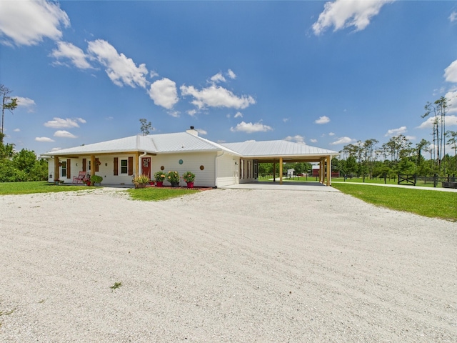 32801 US Highway 441 13 & 14, Okeechobee, FL 34972 - view of front of home with an attached carport, gravel driveway, a front yard, covered porch, and a chimney