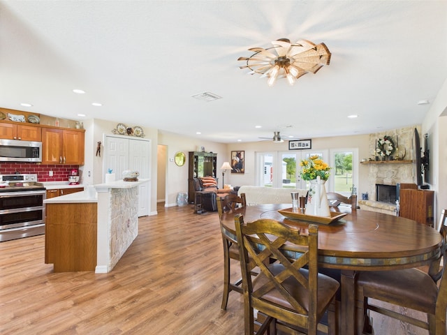 32801 US Highway 441 13 & 14, Okeechobee, FL 34972 - dining room with a fireplace, light wood-style flooring, ceiling fan, recessed lighting, and baseboards