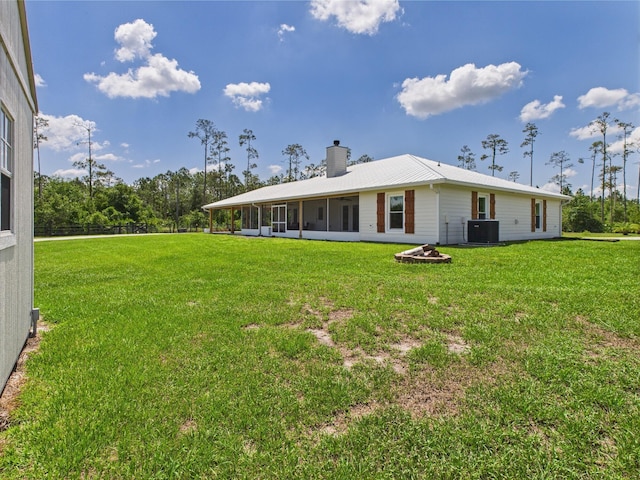 32801 US Highway 441 13 & 14, Okeechobee, FL 34972 - back of property featuring central AC unit, a chimney, a sunroom, and a lawn
