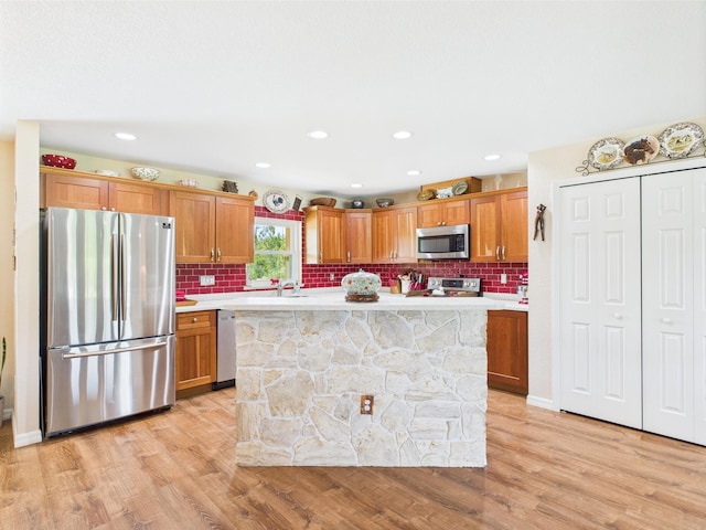 32801 US Highway 441 13 & 14, Okeechobee, FL 34972 - kitchen with stainless steel appliances, light countertops, light wood-type flooring, a sink, and decorative backsplash
