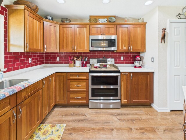32801 US Highway 441 13 & 14, Okeechobee, FL 34972 - kitchen with appliances with stainless steel finishes, brown cabinets, light wood finished floors, backsplash, and recessed lighting