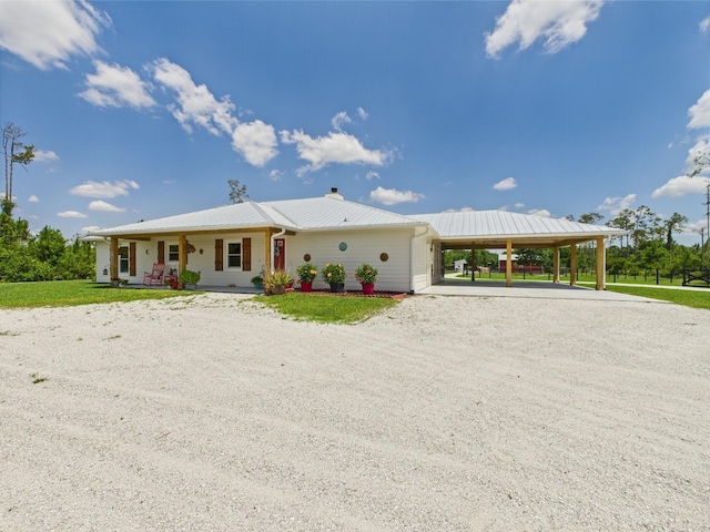 32801 US Highway 441 13 & 14, Okeechobee, FL 34972 - view of front of home with dirt driveway, a porch, a carport, metal roof, and a chimney