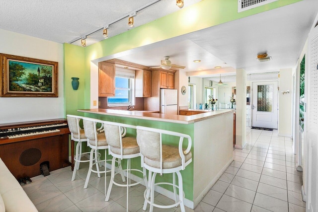 2611 N Riverside Dr Unit 908, Pompano Beach, FL 33062 - kitchen with freestanding refrigerator, track lighting, a ceiling fan, and healthy amount of natural light