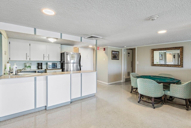 2611 N Riverside Dr Unit 908, Pompano Beach, FL 33062 - kitchen featuring stainless steel appliances, light countertops, a textured ceiling, white cabinetry, and baseboards