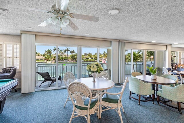 2611 N Riverside Dr Unit 908, Pompano Beach, FL 33062 - carpeted dining area with a textured ceiling, a water view, and a ceiling fan