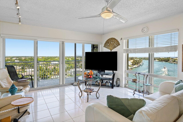 2611 N Riverside Dr Unit 908, Pompano Beach, FL 33062 - living area featuring ceiling fan, plenty of natural light, light tile patterned floors, a textured ceiling, and track lighting