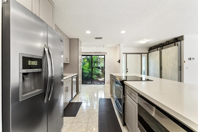 2561 Carambola Cir N Unit 1848Bldg 8, Coconut Creek, FL 33066 - kitchen with appliances with stainless steel finishes, light countertops, a textured ceiling, recessed lighting, and light tile patterned floors